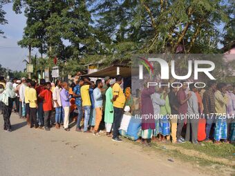 Voters wait in a queue at a polling station to cast votes during the Samaguri assembly constituency bypoll in Nagaon district, Assam, India,...