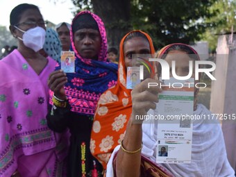 Voters wait in a queue at a polling station to cast votes during the Samaguri assembly constituency bypoll in Nagaon district, Assam, India,...