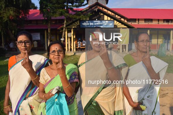 Voters show their ink-marked fingers after casting their ballots at a polling station during the Samaguri assembly constituency bypoll in Na...