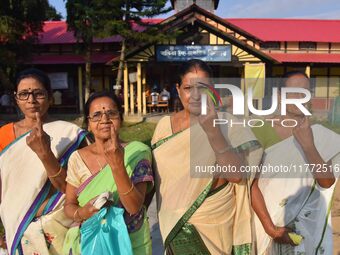 Voters show their ink-marked fingers after casting their ballots at a polling station during the Samaguri assembly constituency bypoll in Na...