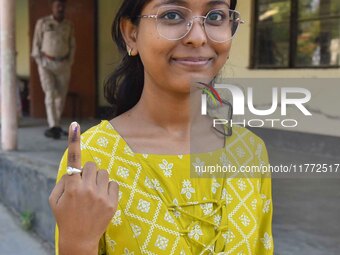 A voter shows her ink-marked finger after casting her ballot at a polling station during the Samaguri assembly constituency bypoll in Nagaon...