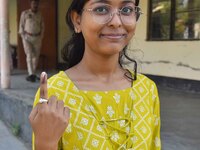 A voter shows her ink-marked finger after casting her ballot at a polling station during the Samaguri assembly constituency bypoll in Nagaon...