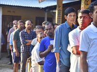 Voters wait in a queue at a polling station to cast votes during the Samaguri assembly constituency bypoll in Nagaon district, Assam, India,...