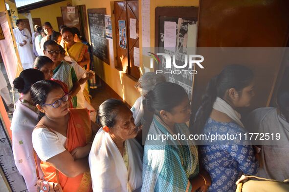 Voters wait in a queue at a polling station to cast votes during the Samaguri assembly constituency bypoll in Nagaon district, Assam, India,...