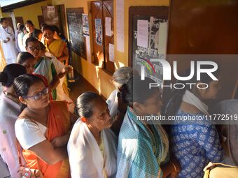 Voters wait in a queue at a polling station to cast votes during the Samaguri assembly constituency bypoll in Nagaon district, Assam, India,...