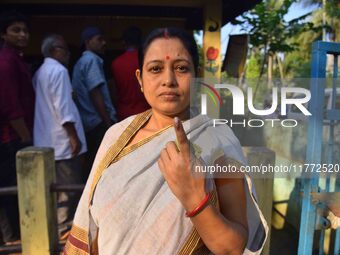 A voter shows her ink-marked finger after casting her ballot at a polling station during the Samaguri assembly constituency bypoll in Nagaon...