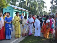 Voters wait in a queue at a polling station to cast votes during the Samaguri assembly constituency bypoll in Nagaon district, Assam, India,...