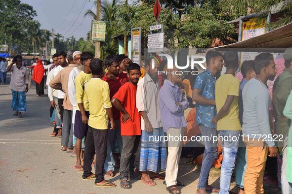 Voters wait in a queue at a polling station to cast votes during the Samaguri assembly constituency bypoll in Nagaon district, Assam, India,...