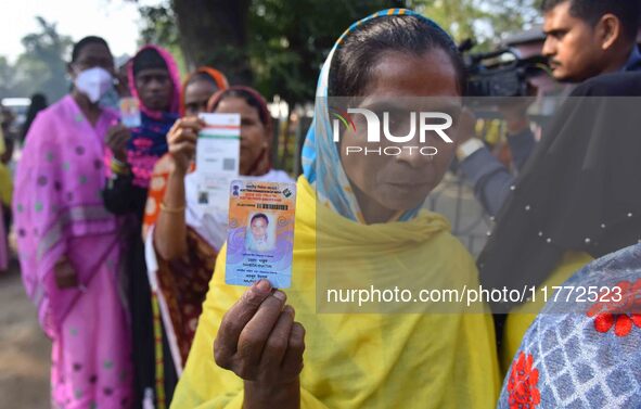 Voters wait in a queue at a polling station to cast votes during the Samaguri assembly constituency bypoll in Nagaon district, Assam, India,...