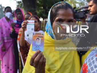 Voters wait in a queue at a polling station to cast votes during the Samaguri assembly constituency bypoll in Nagaon district, Assam, India,...