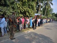 Voters wait in a queue at a polling station to cast votes during the Samaguri assembly constituency bypoll in Nagaon district, Assam, India,...