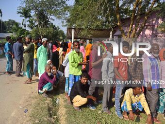 Voters wait in a queue at a polling station to cast votes during the Samaguri assembly constituency bypoll in Nagaon district, Assam, India,...