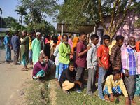 Voters wait in a queue at a polling station to cast votes during the Samaguri assembly constituency bypoll in Nagaon district, Assam, India,...