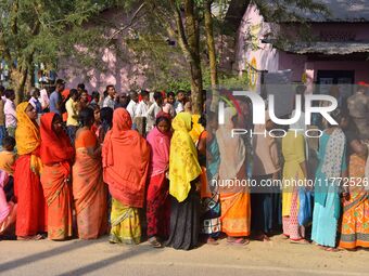 Voters wait in a queue at a polling station to cast votes during the Samaguri assembly constituency bypoll in Nagaon district, Assam, India,...