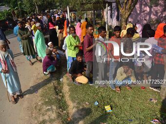 Voters wait in a queue at a polling station to cast votes during the Samaguri assembly constituency bypoll in Nagaon district, Assam, India,...