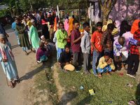 Voters wait in a queue at a polling station to cast votes during the Samaguri assembly constituency bypoll in Nagaon district, Assam, India,...