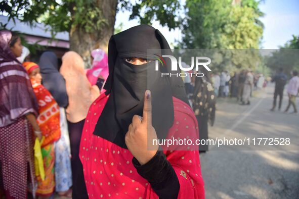 A voter shows her ink-marked finger after casting her ballot at a polling station during the Samaguri assembly constituency bypoll in Nagaon...