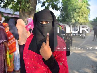 A voter shows her ink-marked finger after casting her ballot at a polling station during the Samaguri assembly constituency bypoll in Nagaon...