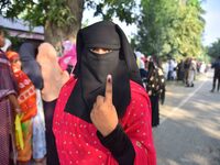 A voter shows her ink-marked finger after casting her ballot at a polling station during the Samaguri assembly constituency bypoll in Nagaon...