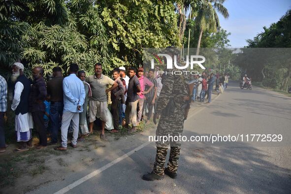 Voters wait in a queue at a polling station to cast votes during the Samaguri assembly constituency bypoll in Nagaon district, Assam, India,...