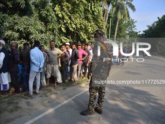 Voters wait in a queue at a polling station to cast votes during the Samaguri assembly constituency bypoll in Nagaon district, Assam, India,...