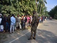 Voters wait in a queue at a polling station to cast votes during the Samaguri assembly constituency bypoll in Nagaon district, Assam, India,...