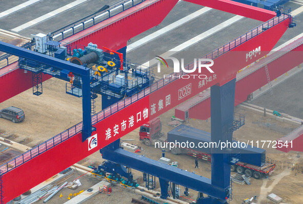 Workers work at the construction site of the third phase of the Canal new port operation zone in Huai'an City, East China's Jiangsu Province...