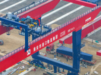 Workers work at the construction site of the third phase of the Canal new port operation zone in Huai'an City, East China's Jiangsu Province...