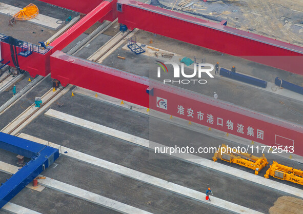 Workers work at the construction site of the third phase of the Canal new port operation zone in Huai'an City, East China's Jiangsu Province...