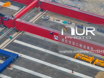 Workers work at the construction site of the third phase of the Canal new port operation zone in Huai'an City, East China's Jiangsu Province...