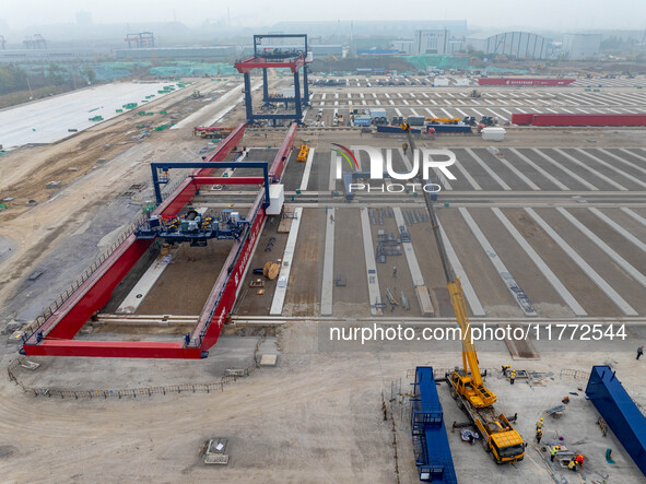 Workers work at the construction site of the third phase of the Canal new port operation zone in Huai'an City, East China's Jiangsu Province...