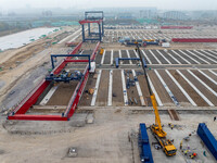 Workers work at the construction site of the third phase of the Canal new port operation zone in Huai'an City, East China's Jiangsu Province...