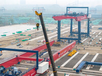 Workers work at the construction site of the third phase of the Canal new port operation zone in Huai'an City, East China's Jiangsu Province...