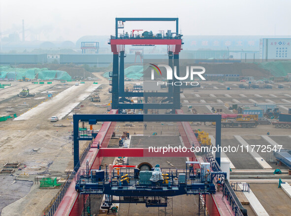 Workers work at the construction site of the third phase of the Canal new port operation zone in Huai'an City, East China's Jiangsu Province...