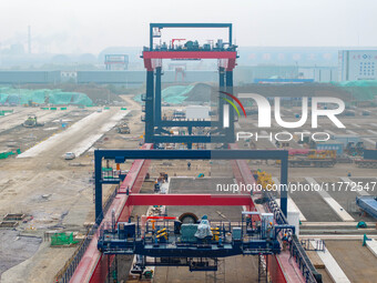 Workers work at the construction site of the third phase of the Canal new port operation zone in Huai'an City, East China's Jiangsu Province...