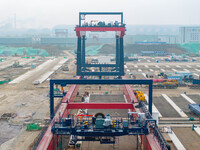 Workers work at the construction site of the third phase of the Canal new port operation zone in Huai'an City, East China's Jiangsu Province...