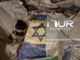 An Iranian newspaper featuring an Israeli flag is seen in a bin in Tehran, Iran, on October 31, 2024. (