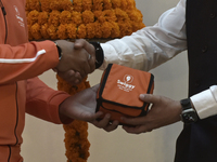 Managing Director and Group Chief Executive Officer of Swiggy, Sriharsha Majety, gives a replica of a Swiggy delivery bag to Managing Direct...