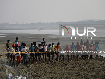 Labourers build a floating pontoon bridge across the river Ganges for devotees ahead of the upcoming Maha Kumbh 2025 festival in Prayagraj,...