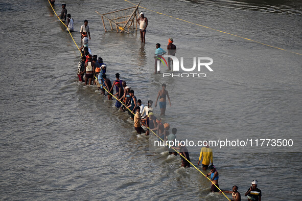 Labourers build a floating pontoon bridge across the river Ganges for devotees ahead of the upcoming Maha Kumbh 2025 festival in Prayagraj,...