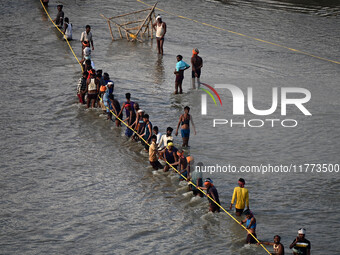 Labourers build a floating pontoon bridge across the river Ganges for devotees ahead of the upcoming Maha Kumbh 2025 festival in Prayagraj,...