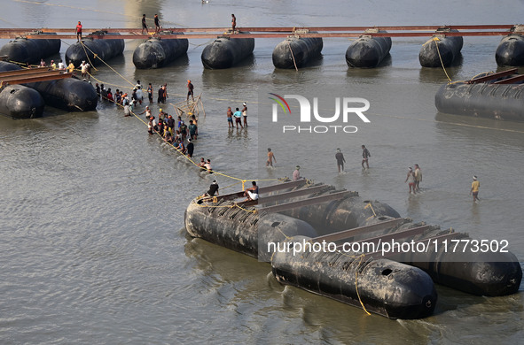 Labourers build a floating pontoon bridge across the river Ganges for devotees ahead of the upcoming Maha Kumbh 2025 festival in Prayagraj,...