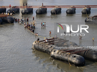 Labourers build a floating pontoon bridge across the river Ganges for devotees ahead of the upcoming Maha Kumbh 2025 festival in Prayagraj,...