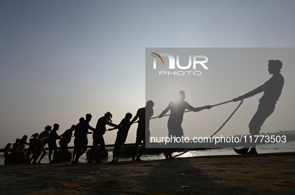 Labourers build a floating pontoon bridge across the river Ganges for devotees ahead of the upcoming Maha Kumbh 2025 festival in Prayagraj,...