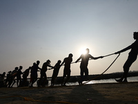 Labourers build a floating pontoon bridge across the river Ganges for devotees ahead of the upcoming Maha Kumbh 2025 festival in Prayagraj,...