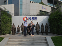 People take a selfie in front of a bull at the National Stock Exchange (NSE) in the business district of Mumbai, India, on November 13, 2024...