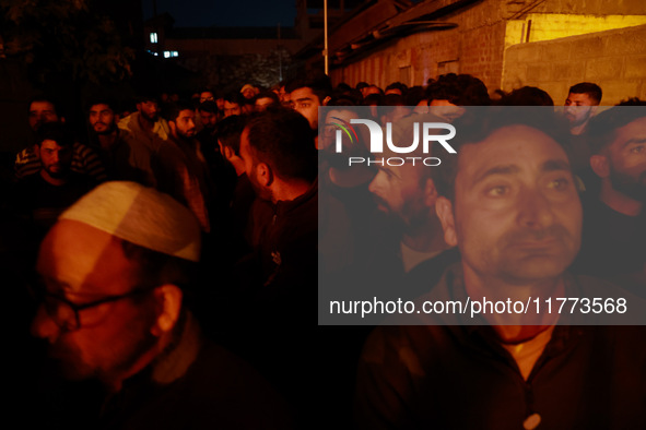 People watch as firefighters try to douse the flames after a fire breaks out in the industrial area of Sopore, Jammu and Kashmir, India, on...