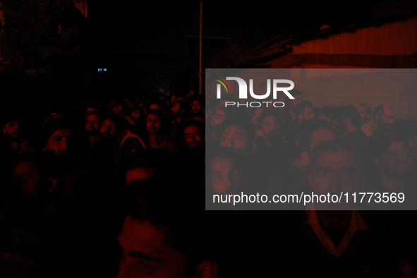 People watch as firefighters try to douse the flames after a fire breaks out in the industrial area of Sopore, Jammu and Kashmir, India, on...