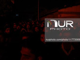 People watch as firefighters try to douse the flames after a fire breaks out in the industrial area of Sopore, Jammu and Kashmir, India, on...