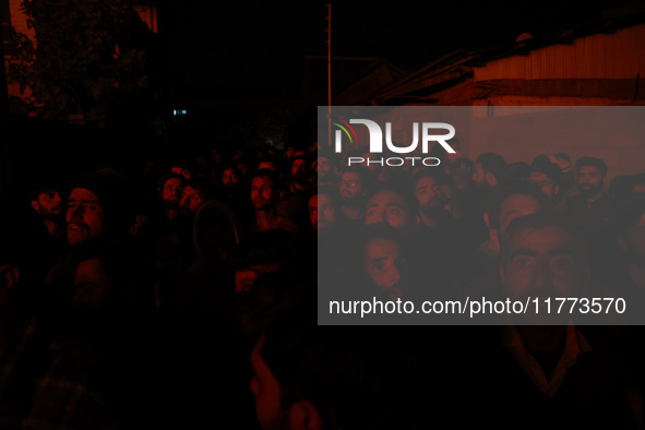 People watch as firefighters try to douse the flames after a fire breaks out in the industrial area of Sopore, Jammu and Kashmir, India, on...